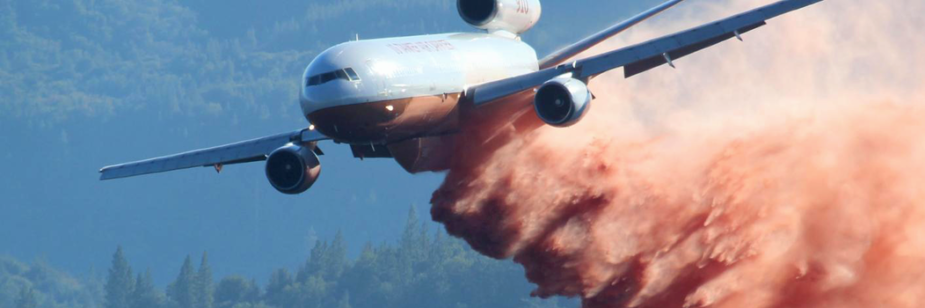 Um avião-tanque DC-10 lançando retardante de fogo sub uma área afetada por um incêndio Imagem: United States Department of Agriculture